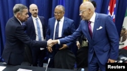 Los delegados jefe de la oposición y el gobierno de Venezuela, Gerardo Blyde (derecha) y Jorge Rodríguez, se estrechan las manos durante la firma de los acuerdos en Barbados, el pasado 17 de octubre de 2023, junto a representantes de esa nación y de Noruega.