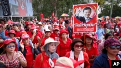 Pendukung pemerintah membawa poster mantan PM Thaksin Shinawatra dalam demo di Aksa, di luar Bangkok, Thailand, Sabtu, 10 Mei 2014. 