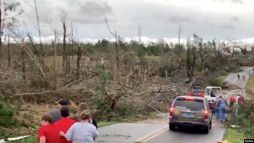 Warga setempat mengamati pembersihan puing-puing di sepanjang jalan pasca tornado di Beauregard, Alabama, AS dalam 3 Maret 2019. (Foto: videograb/Scott Fillmer via Reuters)