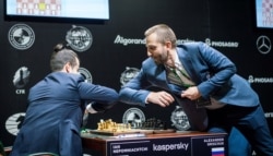 Russian chess players forgo a handshake for an elbow bump as they take part in the Candidates Tournament, organized by the International Chess Federation, in Yekaterinburg, Russia, March 18, 2020.