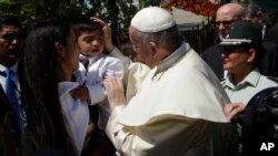 Pope Francis greets the child of an inmate at the San Joaquin women's prison in Santiago, Chile, Jan.16, 2018. 