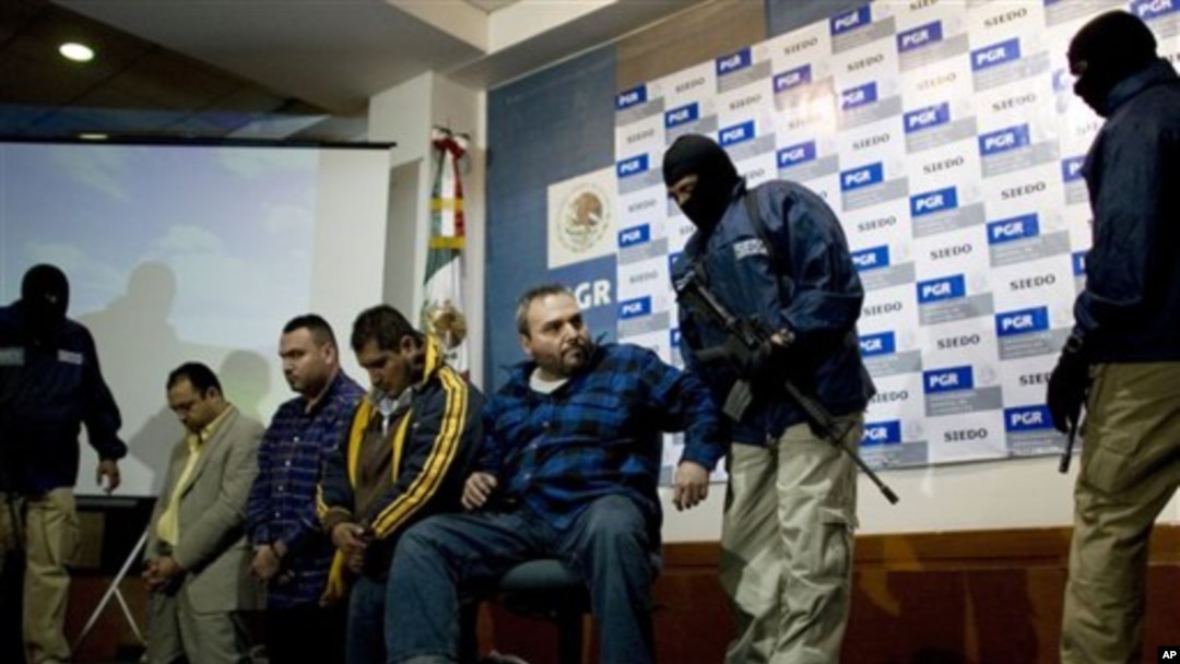 Jesus Zambada Garcia (tengah) satu dari empat pemimpin kartel Sinaloa dikawal oleh empat penjaga bermasker saat dihadapkan di depan wartawan pada konferensi pers pasca penangkapan mereka di Meksiko, 22 Oktober 2008 (Foto: dok).