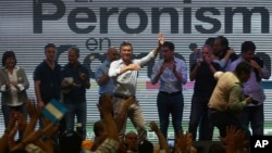 FILE - Argentina's President Mauricio Macri waves to union workers during May Day celebrations in Buenos Aires, Argentina, May 1, 2017.