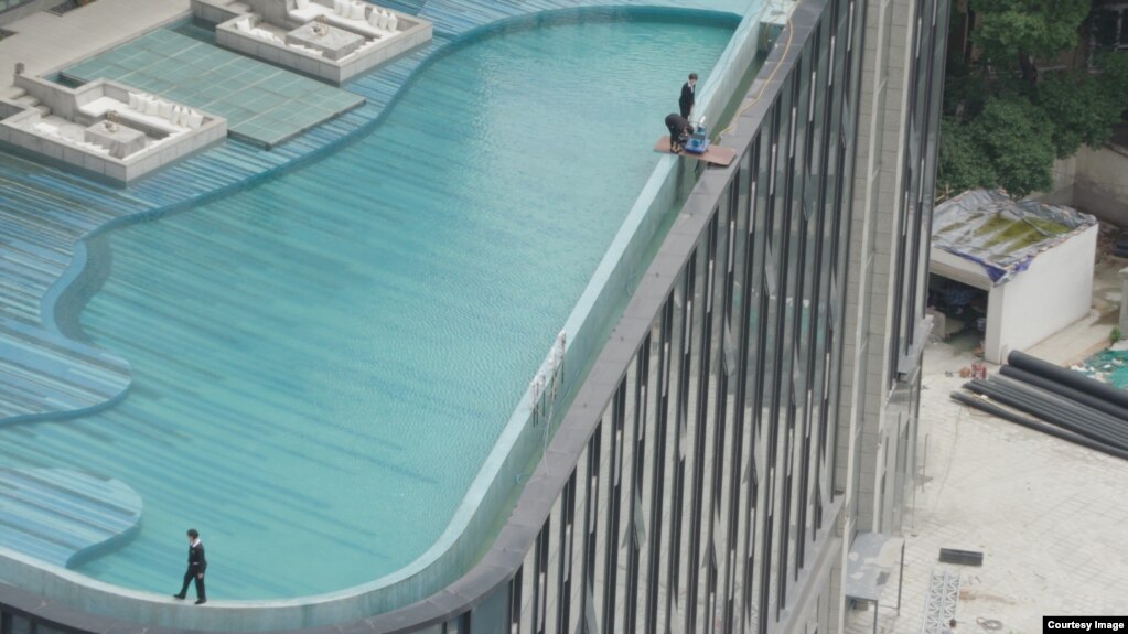 纪录片《登楼叹》中画面，工作人员在中国成都的一个屋顶泳池上工作。Courtesy：麻辣蟹有限责任公司（Mouth Numbing Spicy Crab LLC.）(photo:VOA)
