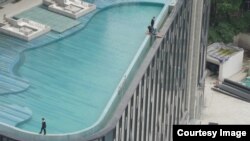 纪录片《登楼叹》中画面，工作人员在中国成都的一个屋顶泳池上工作。Courtesy：麻辣蟹有限责任公司（Mouth Numbing Spicy Crab LLC.）
