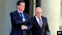 French Prime Minister Manuel Valls, left, and interior minister Bernard Cazeneuve, leave the Elysee Palace in Paris after a cabinet meeting, April 22, 2015. 