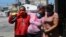 Mariela Jacome, right, helps her mother, Catherine Quinonez, center, who Mariela says suffers symptoms associated with COVID-19, as they arrive at a hospital in Guayaquil, Ecuador, April 16, 2020. 
