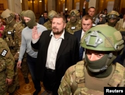 In this Sept. 17, 2015 photo, Ukrainian Secret Service officers arrest lawmaker Ihor Mosiychuk, center, in the Parliament hall in Kyiv, Ukraine.