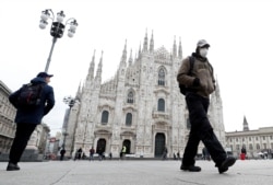 A man wearing a face mask walks past Piazza Duomo square after the government closed cinemas, schools and urged people to work from home and not stand closer than one meter to each other, in Milan, Italy, March 5, 2020.