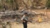 FILE - A Myanmar security officer walks past burned Rohingya houses in Ka Nyin Tan village of suburb Maungdaw, northern Rakhine state of western Myanmar, Sept. 6, 2017.