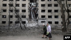 Starice hodaju pored hostela uništenog tokom ruskog bombardovanja grada Seljdove u regionu Donjeck, 14. aprila 2024. godine. (Foto: AFP/Anatolii Stepanov)
