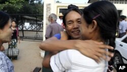 A prisoner, center, is welcomed by her relative outside Insein prison in Rangoon after the government released prisoners, November 15, 2012. 