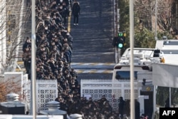 Police officers and investigators leave the residence of impeached South Korean President Yoon Suk Yeol in Seoul, Jan. 15, 2025.