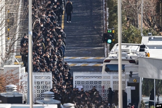 Police officers and investigators leave the residence of impeached South Korean President Yoon Suk Yeol in Seoul, Jan. 15, 2025.