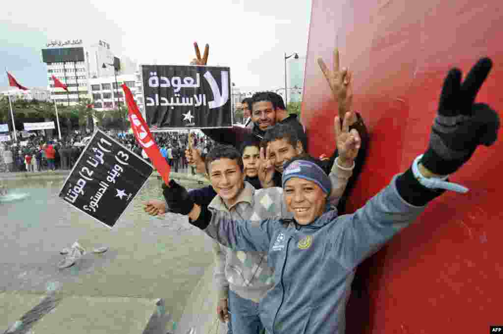 Young Tunisian boys make victory signs during a gathering as part of the festivities marking the second anniversary of the uprising that ousted long-time dictator Zine El Abidine Ben Ali, in Tunis.