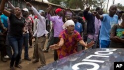 The crowd directs a police vehicle to leave as they demand the resignation of a local police officer because of police cruelty on the previous day, in Kibera slum in Nairobi, Kenya, Oct. 27, 2017.