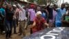 The crowd directs a police vehicle to leave as they demand the resignation of a local police officer because of police cruelty on the previous day, in Kibera slum in Nairobi, Kenya, Oct. 27, 2017.