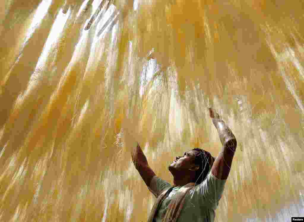 A man dries strands of vermicelli at a factory in the northern Indian city of Allahabad.