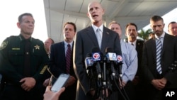 Joined by law enforcement officials, Florida Gov. Rick Scott (center) speaks during a news conference outside Fort Lauderdale–Hollywood International Airport, Jan. 6, 2017, in Fort Lauderdale, Fla.