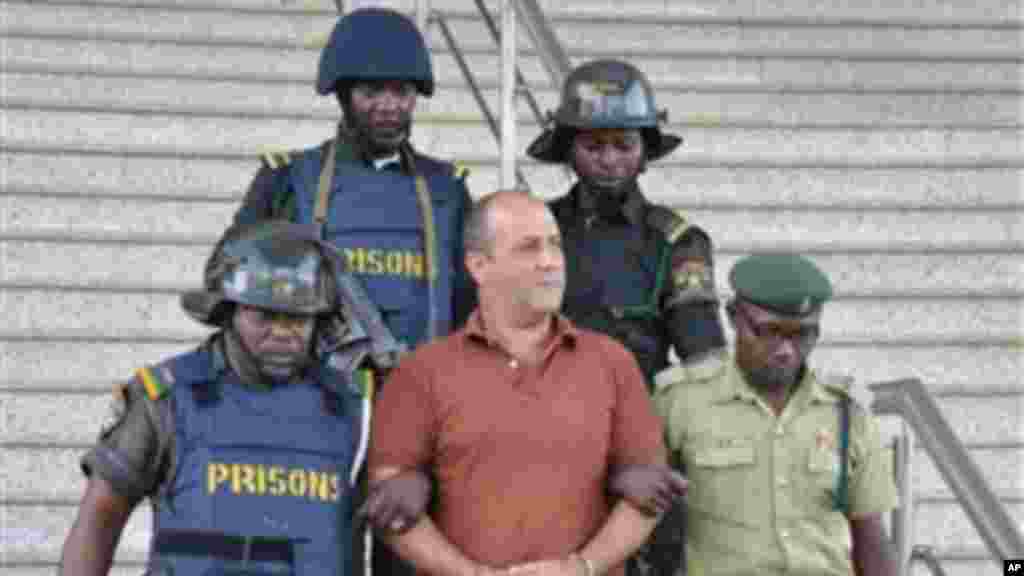 Talal Ahmad Roda, a Nigerian-Lebanese man accused of belonging to Hezbollah, centre, is led out by prison security officers after he was sentenced to life imprisonment at the Federal High Court in Abuja, Nov. 29, 2013.