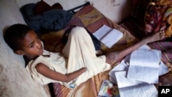 A handout picture released by the United Nations-African Union Mission in Darfur (UNAMID) shows Sudanese Abdulrahim Ahmed Mohammed, 12, sitting in his house at Al-Salam camp for internally displaced people in El-Fasher, the administrative capital of North