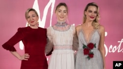 Director Josie Rourke, from left, actresses Saoirse Ronan and Margot Robbie pose for photographers upon arrival at the premiere of the film "Mary Queen of Scots," in London, Dec. 10, 2018.