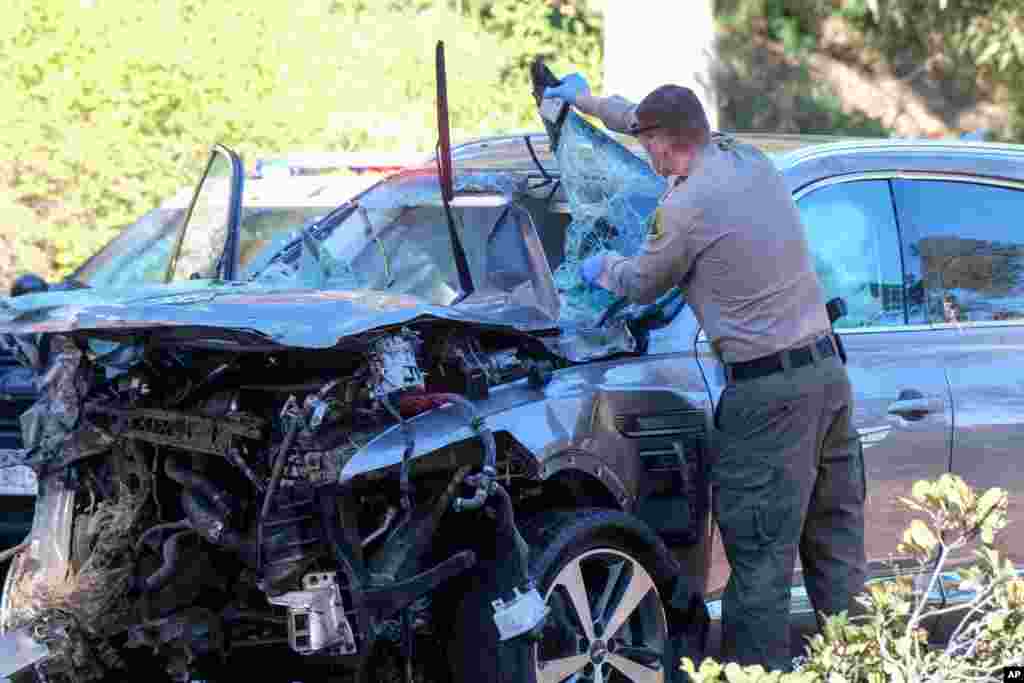 A law enforcement officer inspects a damaged vehicle following a rollover accident involving golfer Tiger Woods, Feb. 23, 2021, in the Rancho Palos Verdes suburb of Los Angeles, California.&#160;