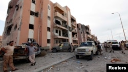 Libyan forces allied with the U.N.-backed government gather in front of ruined buildings at the eastern frontline of fighting with Islamic State militants, in Sirte's neighborhood 650, Libya, Oct. 21, 2016. The six-month fight to oust Islamic State has destroyed much of the city.