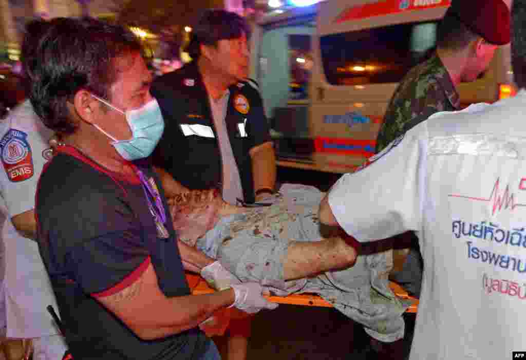 Pekerja penyelamat Thailand membawa korban luka dalam ledakan bom hari Senin (17/8) di dekat sebuah kuil di pusat kota Bangkok.