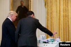 지난해 6월 백악관에서 거대 통신업체 AT&T의 랜달 스티븐슨 최고경영자(오른쪽)가 도널드 트럼프 미국 대통령에게 차세대 이동통신 5G기술을 설명하고 있다.