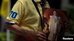 A well-wisher holds a picture of Thailand's King Bhumibol Adulyadej at the Siriraj hospital where he is residing, in Bangkok, Thailand, June 9, 2016.