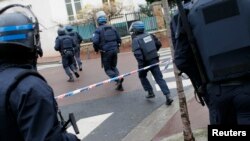 Polisi mengambil posisi di sebuah supermarket di Paris (9/1) ketika mengepung tersangka utama penembakan kantor Charlie Hebdo. 