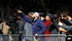 A demonstrator that supports keeping confederate-era monuments in place yells as workers remove the Liberty Place monument Monday, April 24, 2017, which commemorates whites who tried to topple a biracial post-Civil War government, in New Orleans. It was removed overnight in an attempt to avoid disruption from people who want the monuments to stay. (AP Photo/Gerald Herbert)