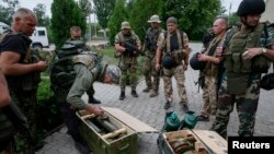 National guard soldiers inspect weapons captured from rebels in Slovyansk, Ukraine, July 6, 2014. 