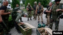 우크라이나 정부군이 슬로뱐스크에서 포로로 잡은 반군의 무기를 검사하고 있다. 