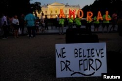 #KremlinAnnex protesters place a sign referring to Christine Blasey Ford, the woman who accused Supreme Court nominee Judge Brett Kavanaugh of a 1982 sexual assault, and spell out the word "AMORAL" on the 66th consecutive day of their demonstration outside the White House, Washington, Sept. 19, 2018.