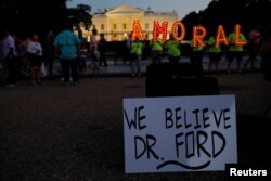 #KremlinAnnex protesters place a sign referring to Christine Blasey Ford, the woman who accused Supreme Court nominee Judge Brett Kavanaugh of a 1982 sexual assault, and spell out the word "AMORAL" on the 66th consecutive day of their demonstration outside the White House.