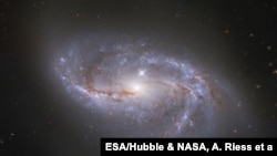 กล้องโทรทรรศน์ NASA/ESA Hubble จับภาพโครงสร้างที่มีลักษณะเหมือนมีแขนมากมายที่ล่องลอยรอบ ๆ กาแล็กซีทรงก้นหอย ที่มีชื่อว่า NGC 2608 ไว้ได้ (Image: ESA/Hubble & NASA, A. Riess et al.)