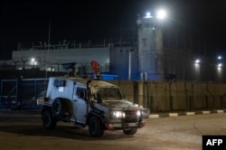 An Israeli army vehicle drives outside Ofer military prison located between Ramallah and Beitunia in the occupied West Bank on Nov. 30, 2023, amid preparations for the release of Palestinian prisoners in exchange for Israeli hostages held by Hamas in Gaza.