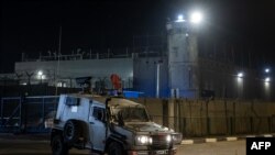 一辆以色列军车行驶在被以色列占领的约旦河西岸拉马拉与贝图西亚之间的奥弗军事监狱外.(2023年11月30日)