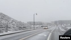 Vehículos transitan entre la nieve en las autopistas de Castaic, en el condado de Los Ángeles, el 25 de febrero de 2023.