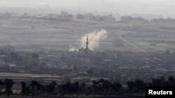 Smoke rises after shells exploded in the Syrian village of al-Rafeed, close to the cease-fire line between Israel and Syria, as seen from the Israeli occupied Golan Heights May, 7, 2013. 