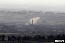 FILE - Smoke rises after shells exploded in the Syrian village of al-Rafeed, close to the cease-fire line between Israel and Syria, as seen from the Israeli occupied Golan Heights May, 7, 2013.