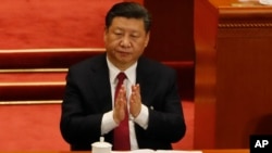 FILE - Chinese President Xi Jinping applauds, March 9, 2018, China's Procurator-General Cao Jianming during a plenary session of China's National People's Congress at the Great Hall of the People in Beijing. 