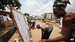 Residents check for their names on the voters registration list in Lagos, Nigeria, Feb. 18, 2011
