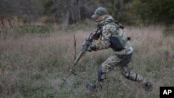 (FILE) A recruit holds his weapon as he runs during a military training in southern Russia.