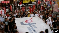 Thousands of people march on a downtown street in Hong Kong Sunday, June 1, 2014, to mark the 25th anniversary of China's bloody crackdown on Tiananmen Square protests on June 4, 1989.