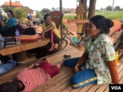 Some villagers look after children who have been diagnosed with dengue fever at a private health clinic in the village, June 2019. (Sun Narin/VOA Khmer)