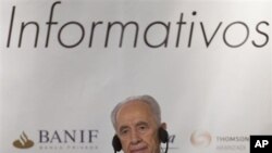 Israeli President Shimon Peres adjusts his headphones during a breakfast conference in a hotel in Madrid, Spain, February 23, 2011