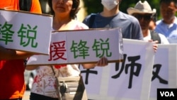 一些华人举牌支持遭到中国维稳当局打压的锋锐律师事务所（美国之音国符拍摄）